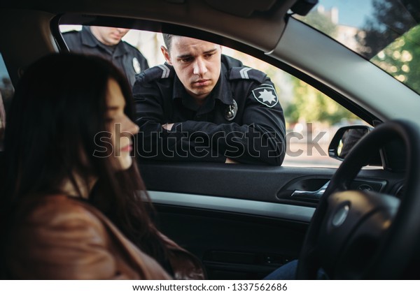 Police officers\
in uniform check female driver\
