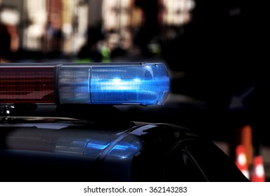 Police Patrol Car With Flashing Lights And Siren On During The Night Raid Against Crime