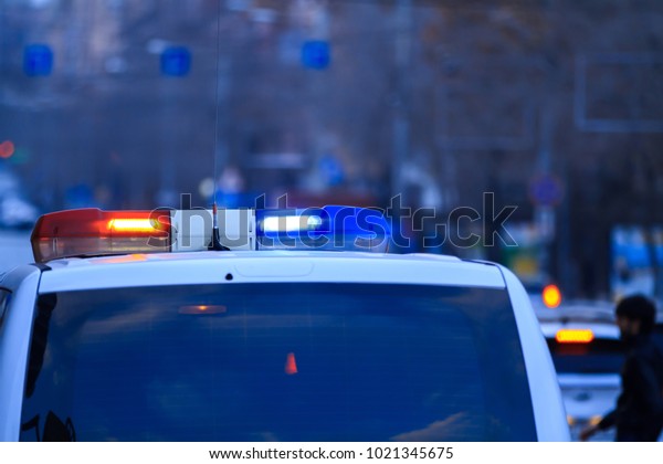 Police patrol car with flashing lights and siren on\
during the night 