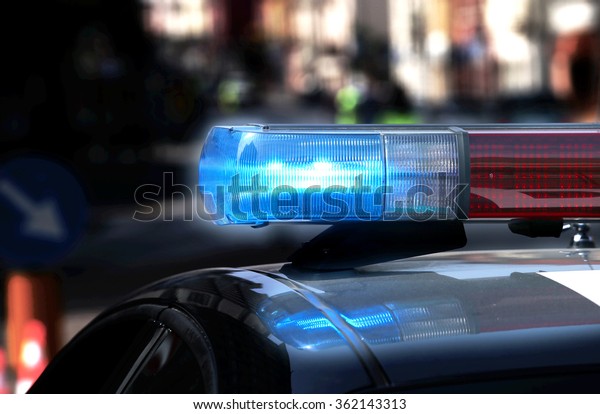 Police patrol car with flashing lights and\
siren on during the night raid against\
crime