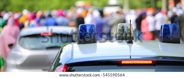 Police patrol car with flashing lights and a\
police car undercover during the\
riot