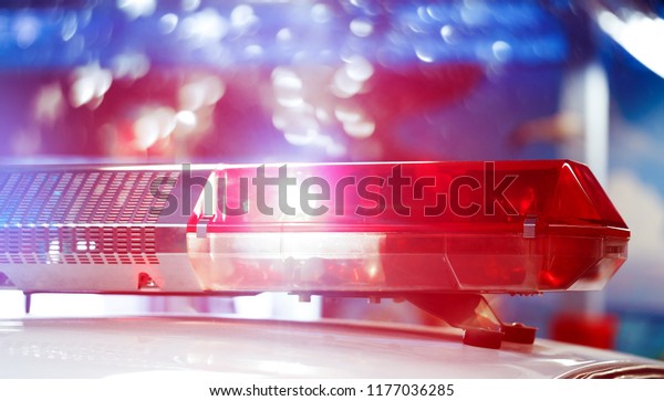 Police patrol car of the specialized unity in the\
night time. Red and blue flashes on the car of the emergency\
vehicle. Police lights during traffic surveillance on the city\
road. Flash lights.
