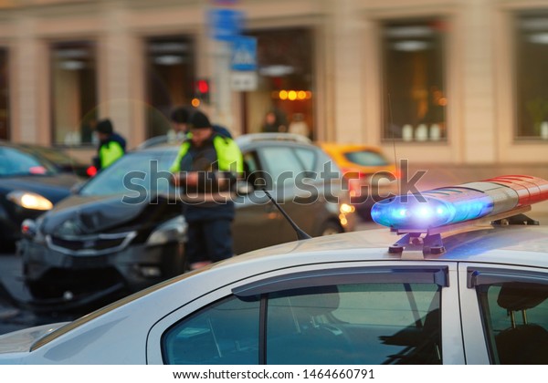 Police patrol cars with red and blue flashing
siren on the road.  Automobile collision on the road. Investigating
car accident, road crash. Police officer on background. Police
vehicle