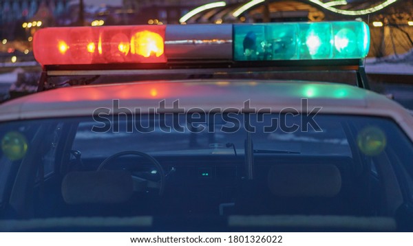 Police\
patrol at night. City street in winter. Harassment of the offender.\
To protect and serve. American car, 80s. Offense against the law.\
Police forces. Defocused cityscape as\
background.