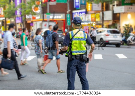 The police patrolling at the crossroads to guard the safety of the people（The text is: Police）