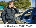 Police, radio and security with a man officer outdoor on patrol while talking to headquarters for a situation report. Law, safety and communication with a policeman on the street for justice