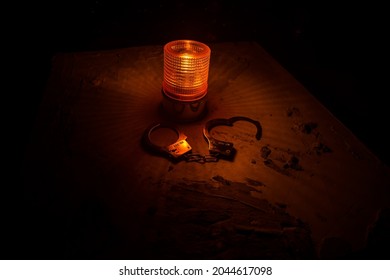 Police Raid At Night And You Are Under Arrest Concept. Silhouette Of Handcuffs With Flashing Red Police Light At Foggy Background. Selective Focus