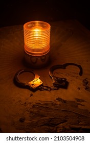 Police Raid At Night And You Are Under Arrest Concept. Silhouette Of Handcuffs With Flashing Red Police Light At Foggy Background. Selective Focus