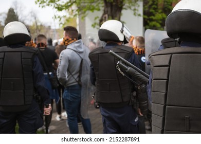 Police Rifle Barrel And Masked People In The Background.