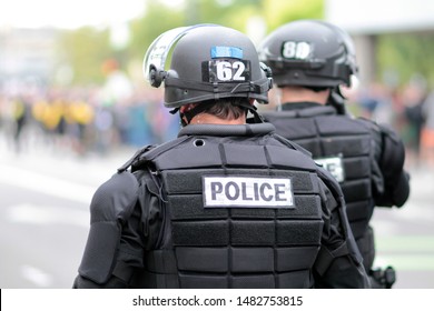 Police In Riot Gear Overseeing A Crowd Of Protestors.