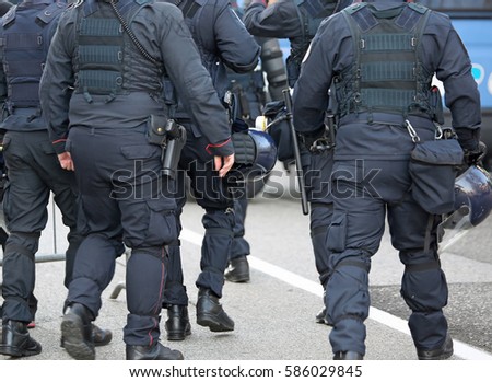 police in riot gear with protective helmet waiting for the fans of the soccer teams before the important match