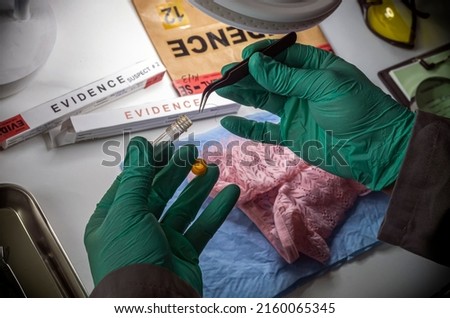 Police scientist inserts rape victim's hair into vial for crime lab DNA research, conceptual image