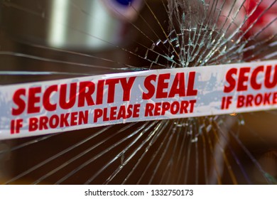 Police Security Seal Tape Across Broken Glass Window