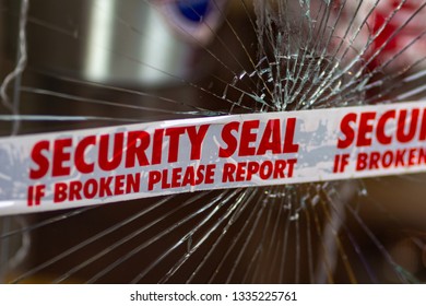 Police Security Seal Tape Across Broken Glass Window