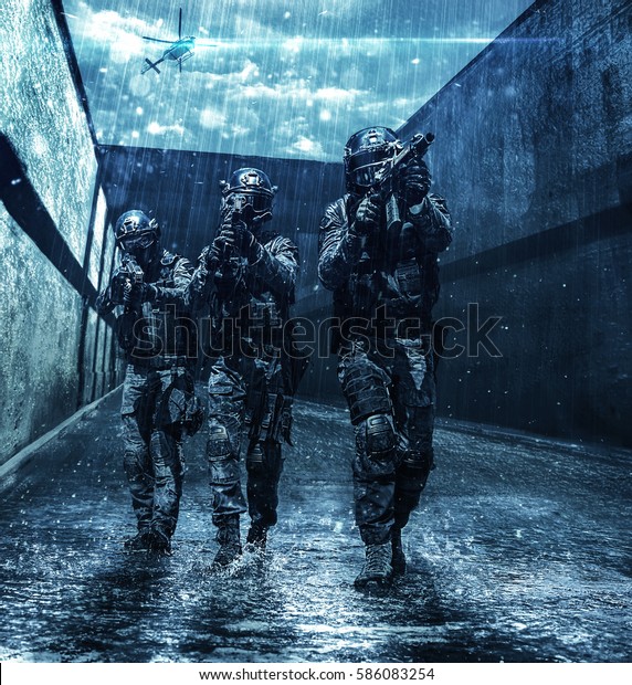 Police squad moving across sewer tunnel during\
mission. Police helicopter supporting from air. Raining cloudy\
weather, they are wet and\
drenched
