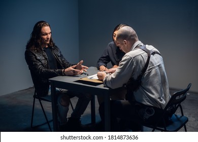 In The Police Station's Interrogation Room, Good And Bad Cops Are Questioning A Theft Suspect In A Leather Jacket