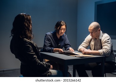 In The Police Station's Interrogation Room, Good And Bad Cops Are Questioning A Theft Suspect In A Leather Jacket.