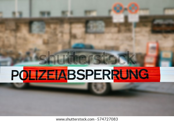 Police tape in\
Germany at the crime scene with the inscription in German \