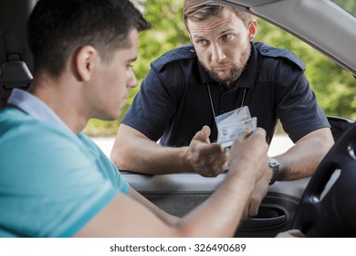 Policeman checking young male driver's documents