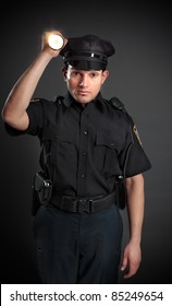 A Policeman, Night Patrolman Or Security Guard Shining A Flashlight Torch To Investigate Or Search.