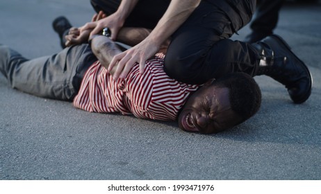 Policeman Putting Handcuffs On Crying Black Man