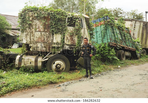 Policemen on a road with abandoned truck\
wreck at Quirigua on Guatemala, 24 january\
2014