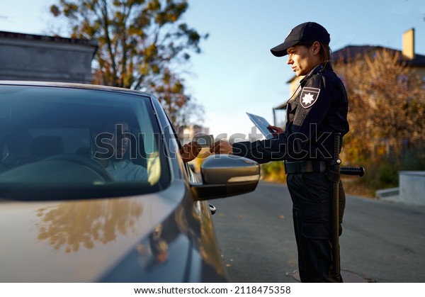 Policewoman stop car\
and check driver\
license