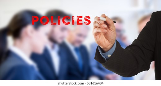 Policies, Male hand in business wear holding a thick pen, writing on an imaginary screen at the camera, business team in background, digital composing.