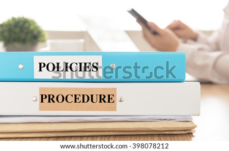 Policies and Procedures doucument place on desk in meeting room.  Policy, Procedure concept.