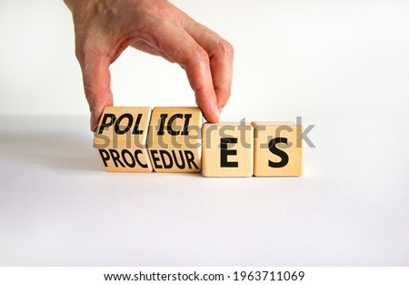 Policies vs procedures symbol. Businessman turns wooden cubes, changes the word 'procedures' to 'policies'. Beautiful white table, white background, copy space. Business, policies, procedures concept.