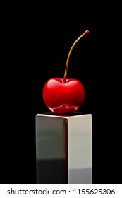 Polish Cherry On A Chromed Plinth On A Black Background