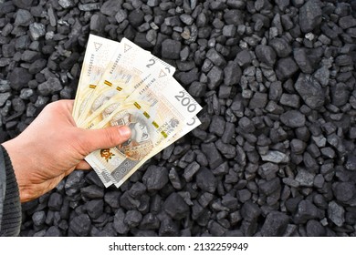 Polish currency showed on coal of mine deposit mineral resources background whose prices increase during high inflation in Poland