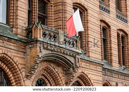 Polish flag on a balcony of historic red brick building of post office