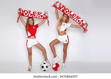 Polish girls in sports outfits hold the Polish red and white flag and support the Polish team in the soccer championship. Polish representation - Powered by Shutterstock