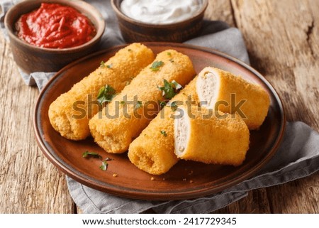 Polish Krokiety are made from rolled crepes, filled with stuffing meat, then breaded and pan-fried closeup on the plate on the wooden table. Horizontal
 Zdjęcia stock © 