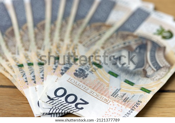 Polish money. Stack of bank note from\
Poland. 200 zl. Two hundred polish zloty. Polish currency close up\
macro. Money inflation, growing prices or savings.\
