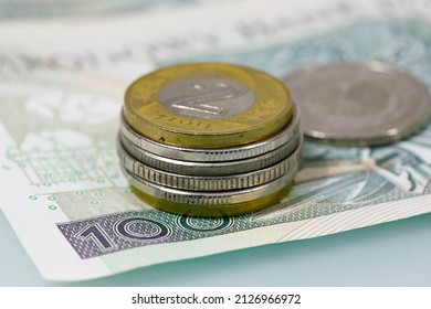 Polish money. Polish zloty coins stacked next to each other on banknotes are now the background for various financial matters. PLN currency. - Shutterstock ID 2126966972