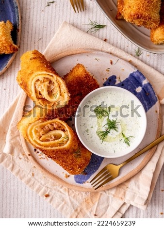 Polish traditional vegetarian krokiety snack served for breakfast with tzatziki sauce. Croquet are filled with sauerkraut and mushrooms, fried in oil, and served as an appetizer, side dish, or dinner Zdjęcia stock © 