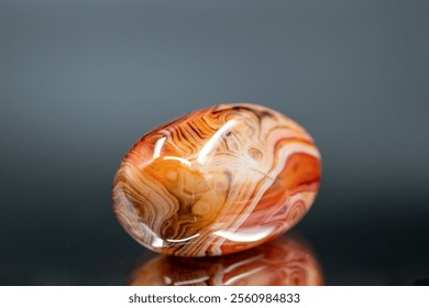 A polished agate natural stone reveals its banded patterns and smooth surface, showcasing vibrant colors and refined elegance - Powered by Shutterstock