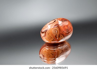 A polished agate natural stone reveals its banded patterns and smooth surface, showcasing vibrant colors and refined elegance - Powered by Shutterstock