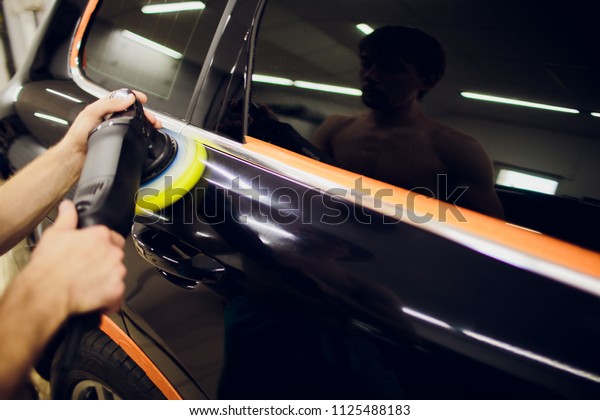 Polished black car polishing machine\
polished finishing. Car detailing. Selective\
focus.