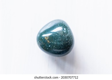 Polished bloodstone or heliotrope jasper stone on a white background - Natural mineral rock specimen