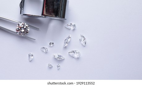Polished diamonds of different cuts and sizes on light background with copy space top view.