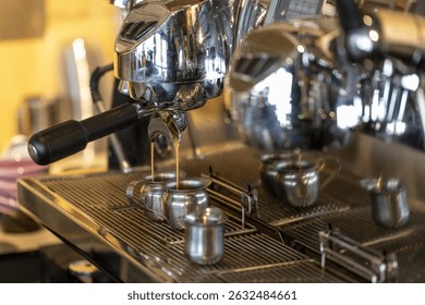A polished espresso machine in action, with multiple cups placed beneath the spouts, capturing a warm café ambiance.