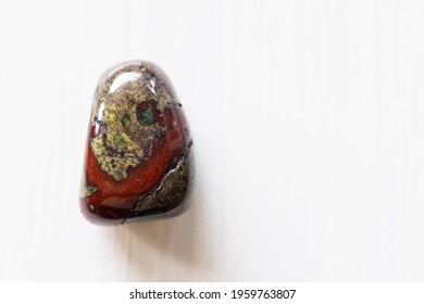 Polished tumbled stone heliotrope jasper or dragon's blood stone on a white background - natural mineral