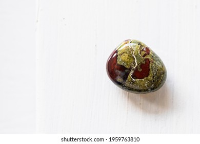 Polished tumbled stone heliotrope jasper or dragon's blood stone on a white background - natural mineral