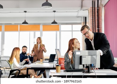 Polite Director Gives Directions And Advice To His Employee Working At The Computer In The Office, Successful Team