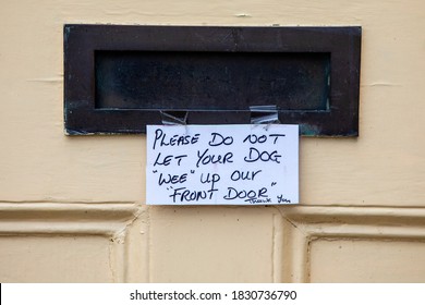 A Polite Handwritten Now On The Letterbox Of A House In The UK, Asking Passers-by To Not Let Their Dog Wee Up Their Front Door.