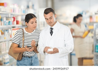 Polite male pharmacist consulting young girl about medicament in box in chemist's shop - Powered by Shutterstock