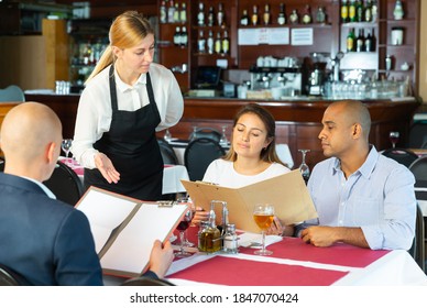 Polite Waitress Offers To Choose A Dish From The Menu